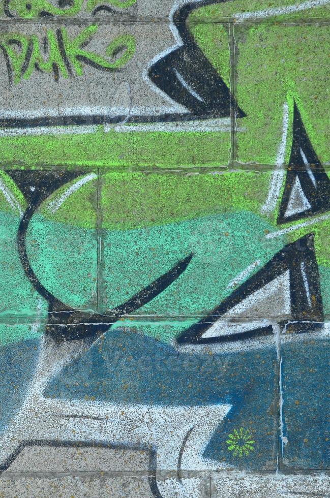 fragment van graffiti tekeningen. de oud muur versierd met verf vlekken in de stijl van straat kunst cultuur. gekleurde achtergrond structuur in groen tonen foto