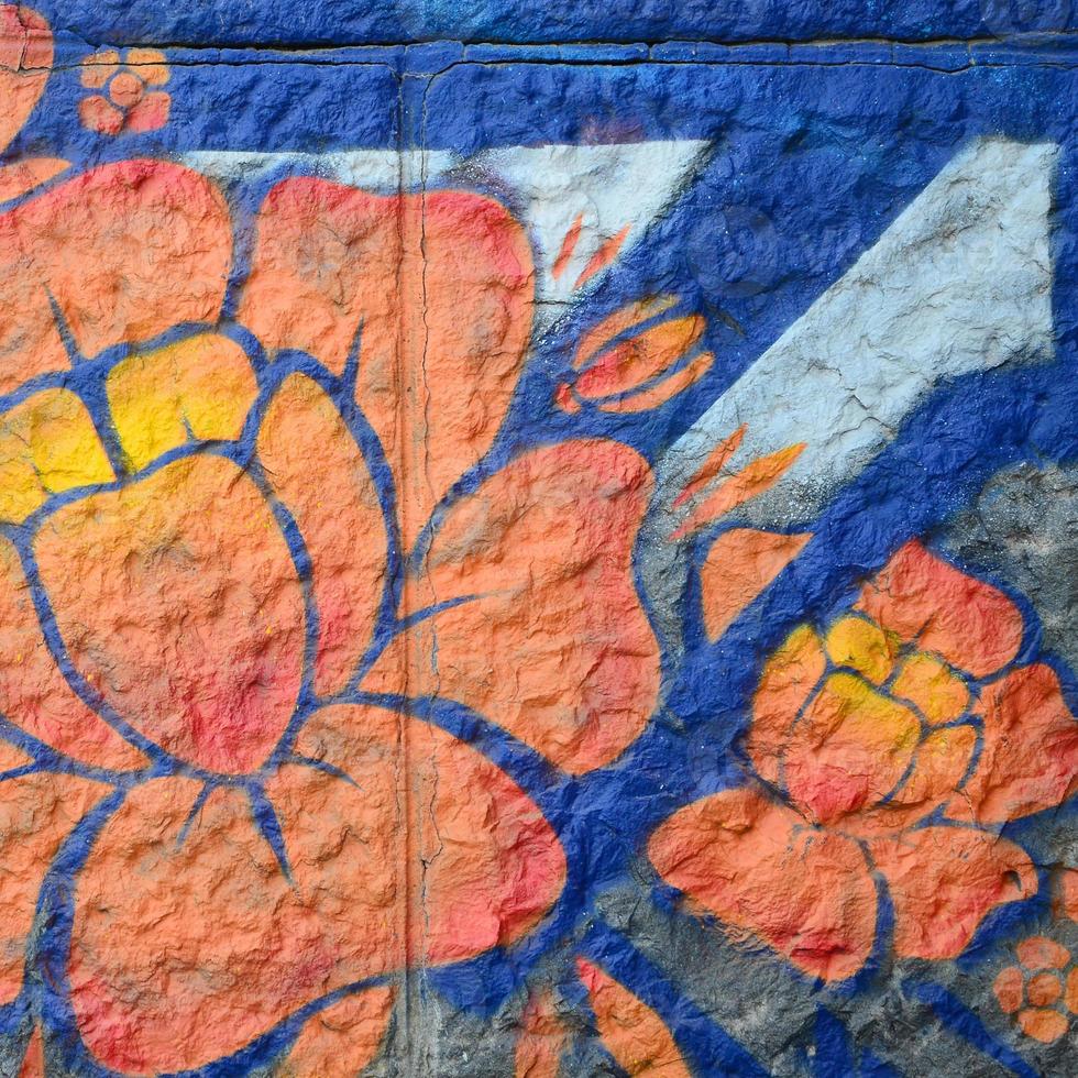 fragment van graffiti tekeningen. de oud muur versierd met verf vlekken in de stijl van straat kunst cultuur. oranje bloem foto