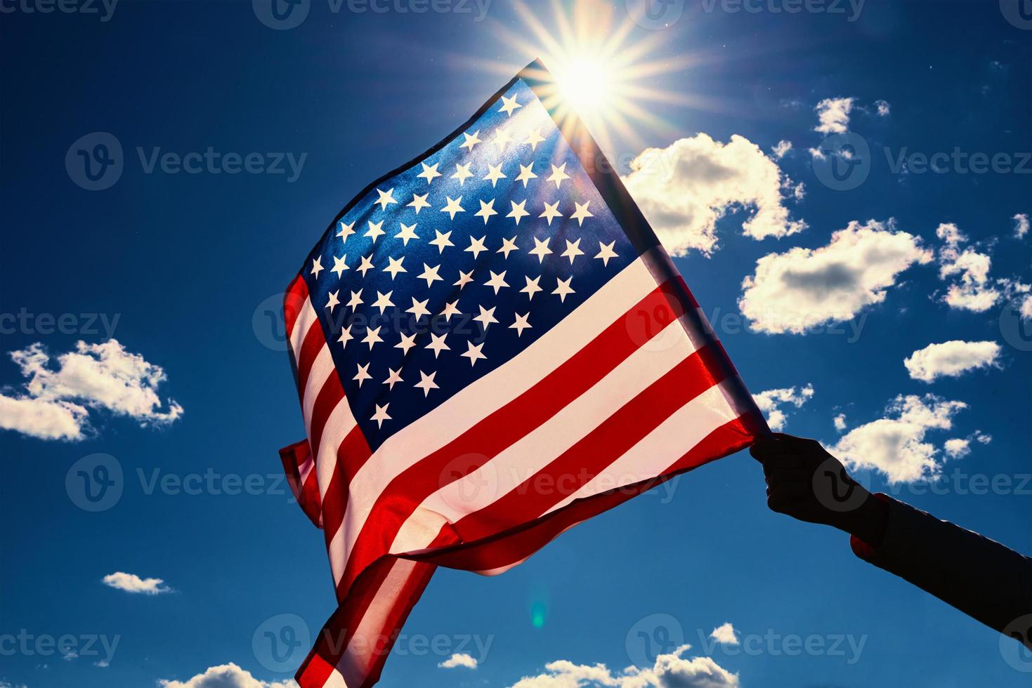 golvend Verenigde Staten van Amerika vlag in hand- tegen blauw lucht foto
