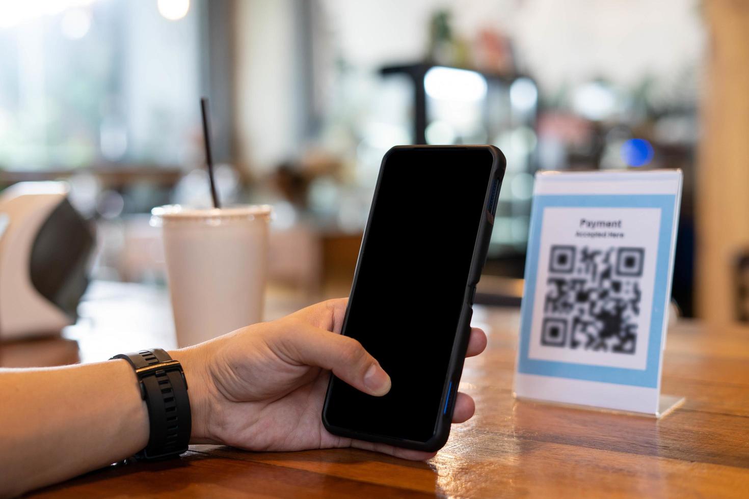 Mens gebruik smartphone naar scannen qr code naar betalen in cafe restaurant met een digitaal betaling zonder contant geld. Kiezen menu en bestellen accumuleren korting. e portemonnee, technologie, betalen online, credit kaart, bank app foto