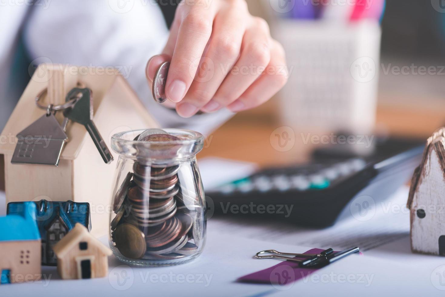 Mens zet munten in een glas pot, concept van een lening voor huisvesting, goedkeuring van credit voor de aankoop van echt landgoed, zaken en financiën idee, thuis lening herfinanciering,financieel rijkdom beheer foto