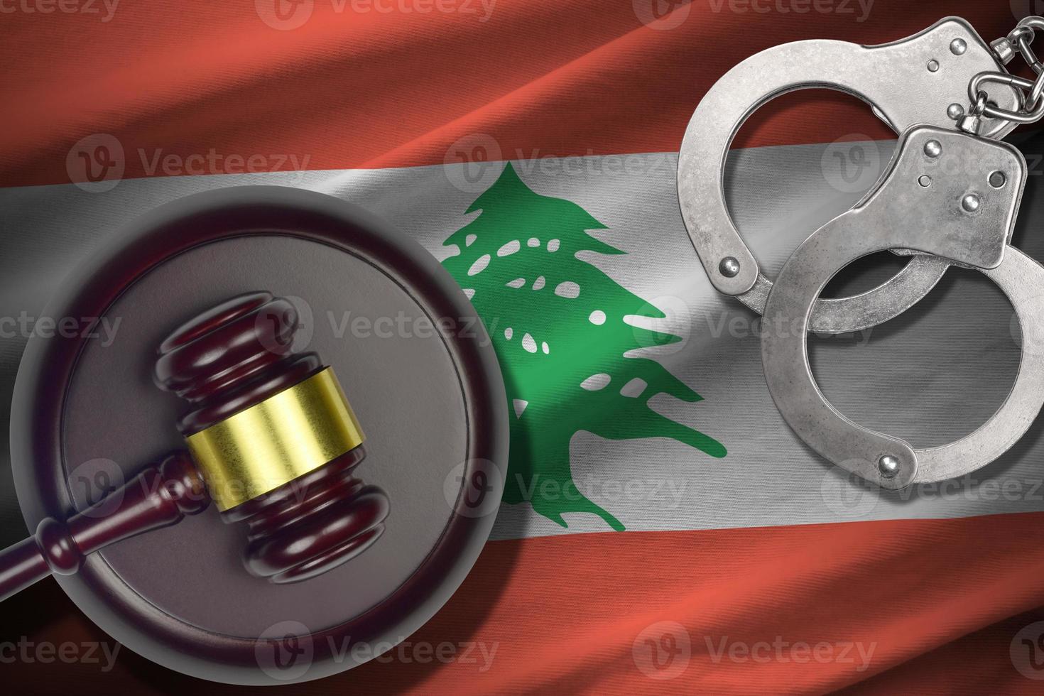 Libanon vlag met rechter hamer en handboeien in donker kamer. concept van crimineel en straf, achtergrond voor oordeel topics foto