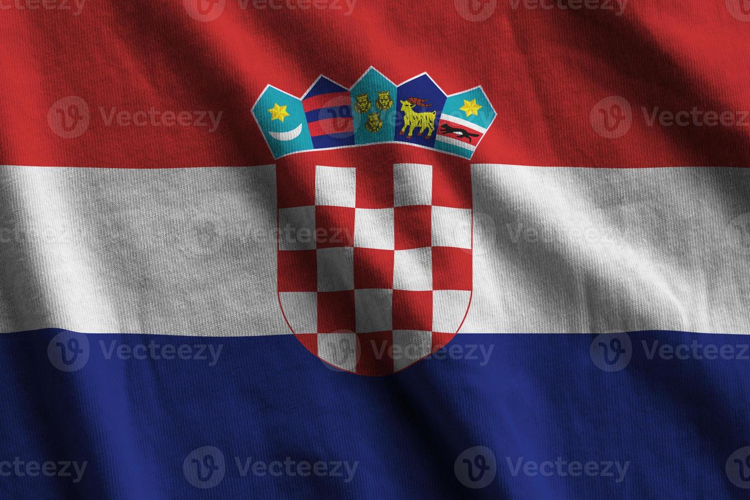 Kroatië vlag met groot vouwen golvend dichtbij omhoog onder de studio licht binnenshuis. de officieel symbolen en kleuren in banier foto