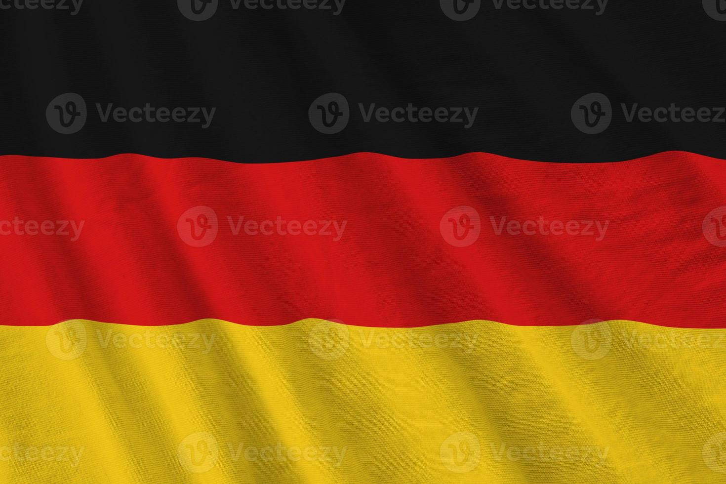 Duitsland vlag met groot vouwen golvend dichtbij omhoog onder de studio licht binnenshuis. de officieel symbolen en kleuren in banier foto