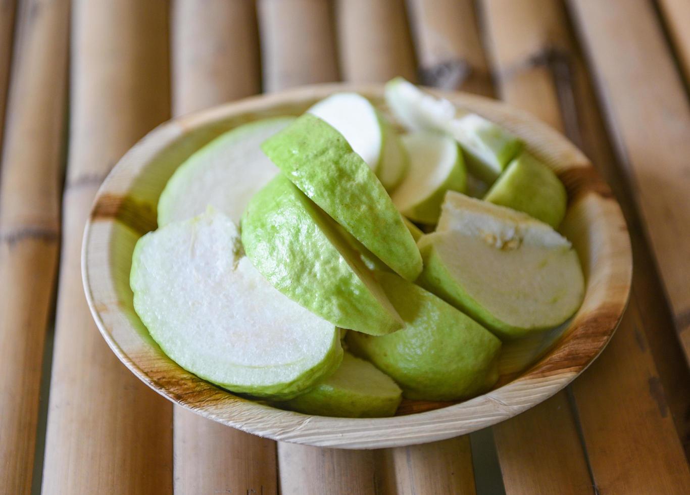 groen guava fruit - guava plak Aan natuur bord Aan houten achtergrond foto