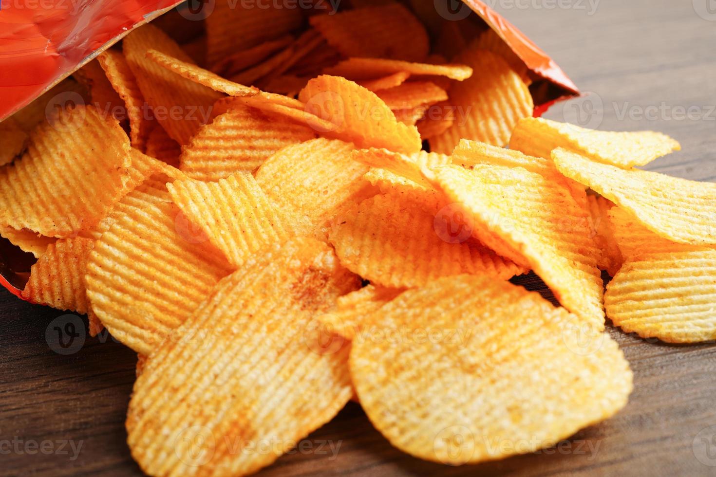 Aardappelchips in open zak, heerlijke bbq-kruiden pittig voor crips, dun plakje gefrituurd snack fastfood. foto