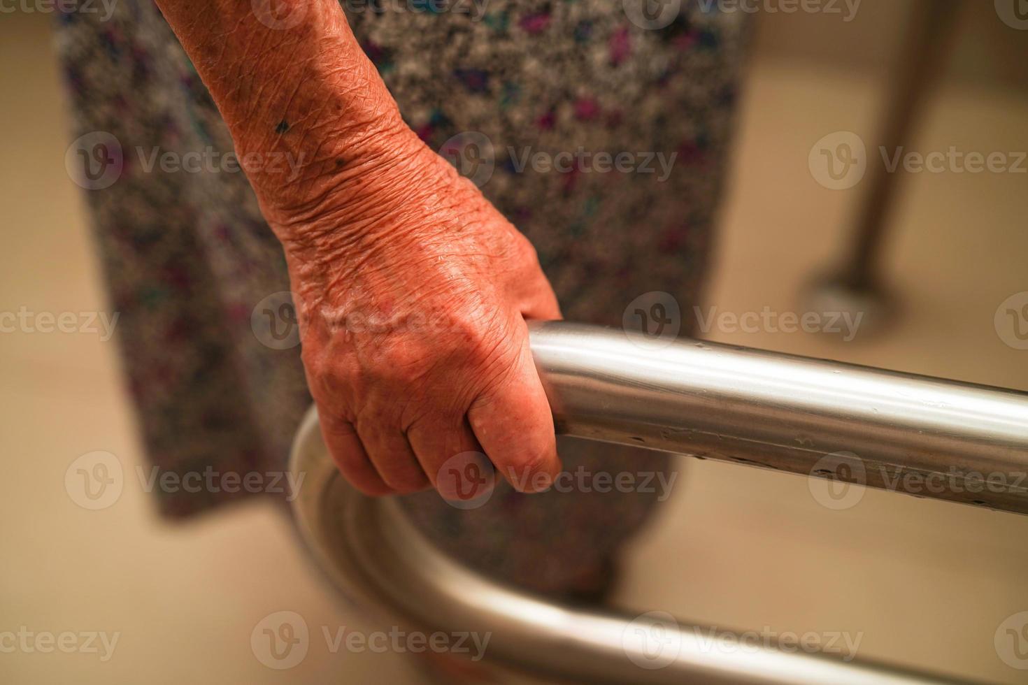 Aziatische bejaarde oude vrouw patiënt gebruik toilet steunrail in badkamer, leuning veiligheid handgreep, beveiliging in verpleegziekenhuis. foto