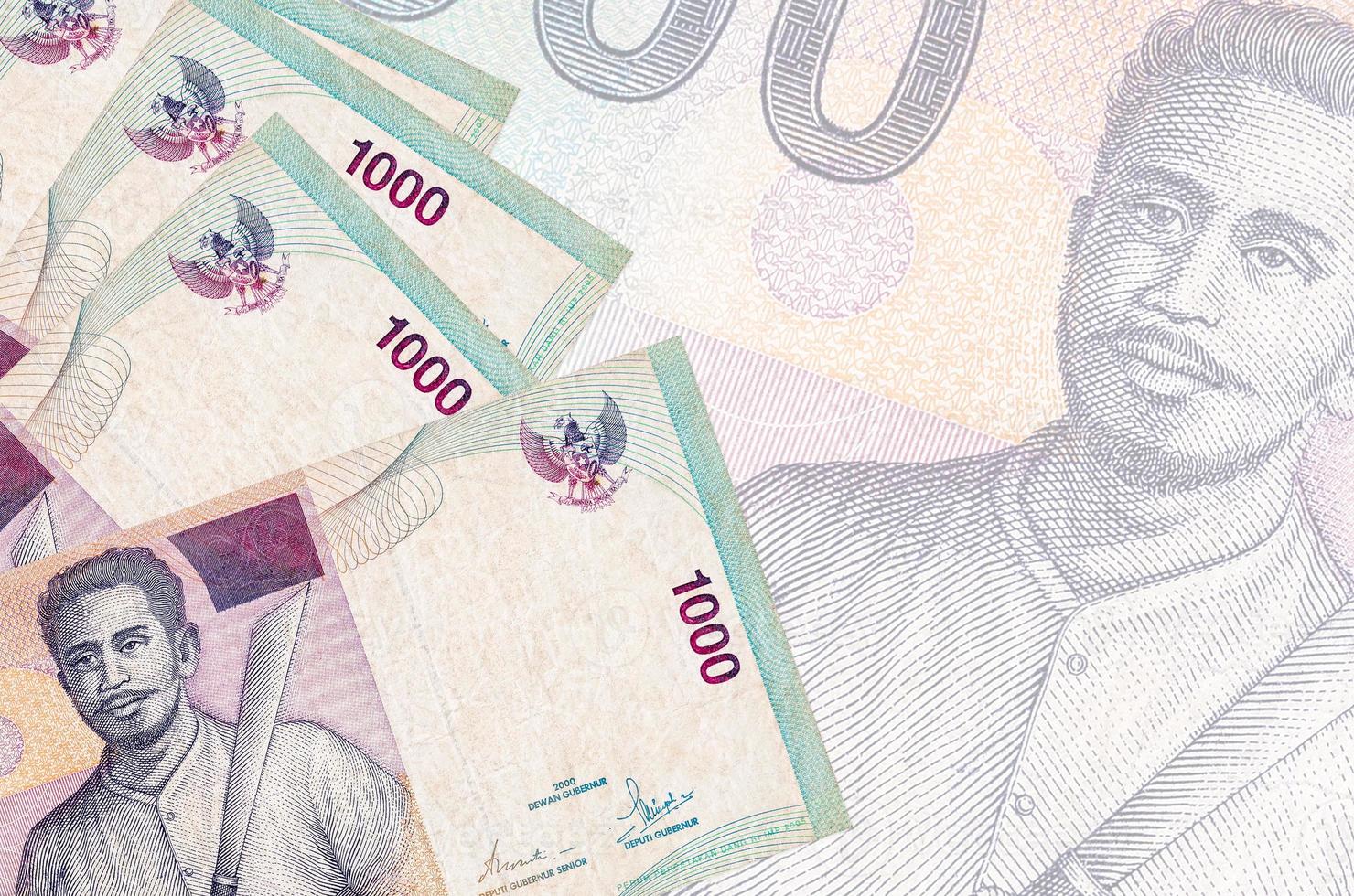 1000 Indonesisch roepia rekeningen leugens in stack Aan achtergrond van groot semi-transparant bankbiljet. abstract bedrijf achtergrond foto