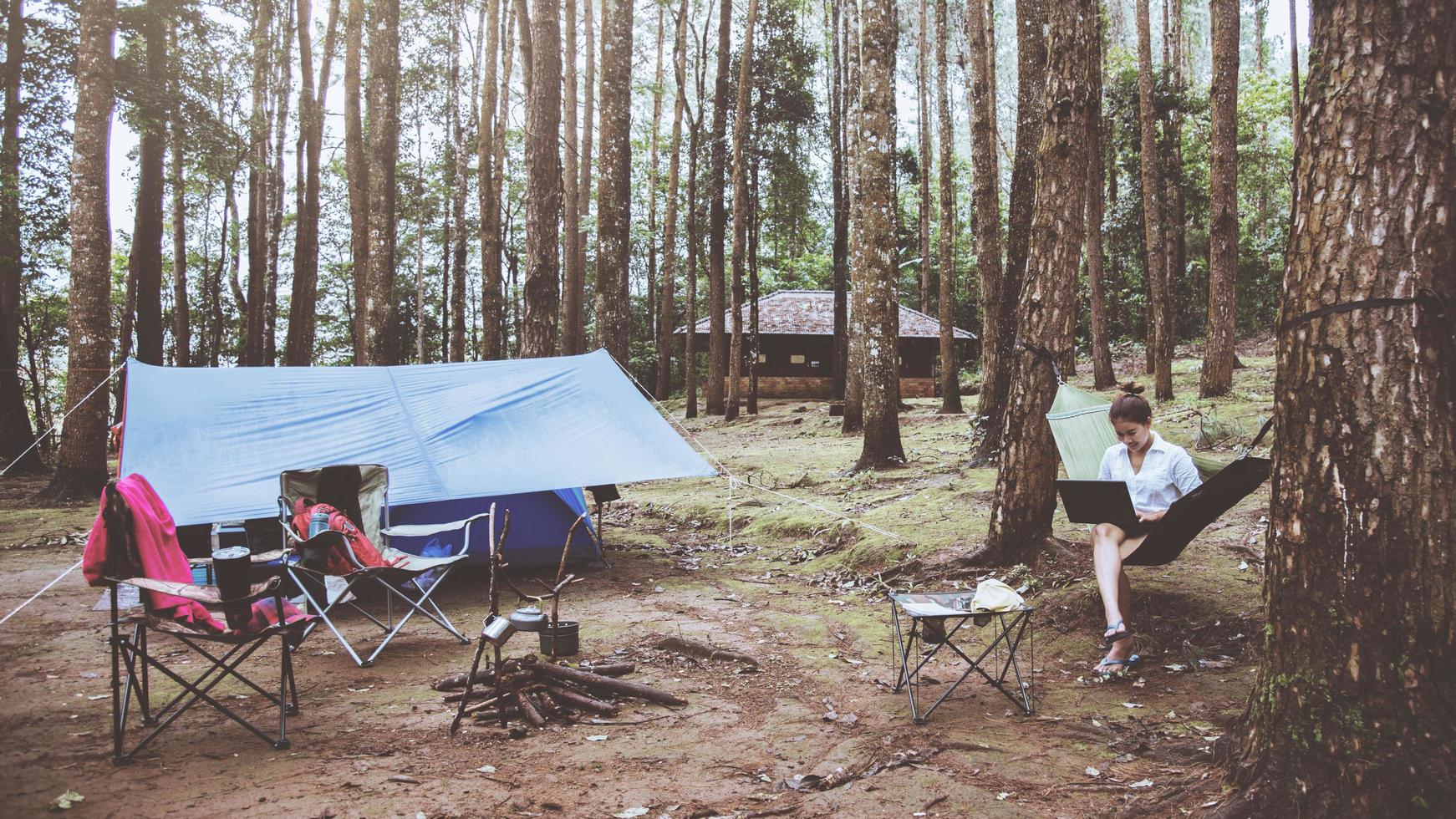 Aziatische vrouwen reizen natuurlijk ontspannen. zittend werken met behulp van een notebook. in de hangmat. camping in het nationale park doi inthanon in chiangmai. in Thailand foto