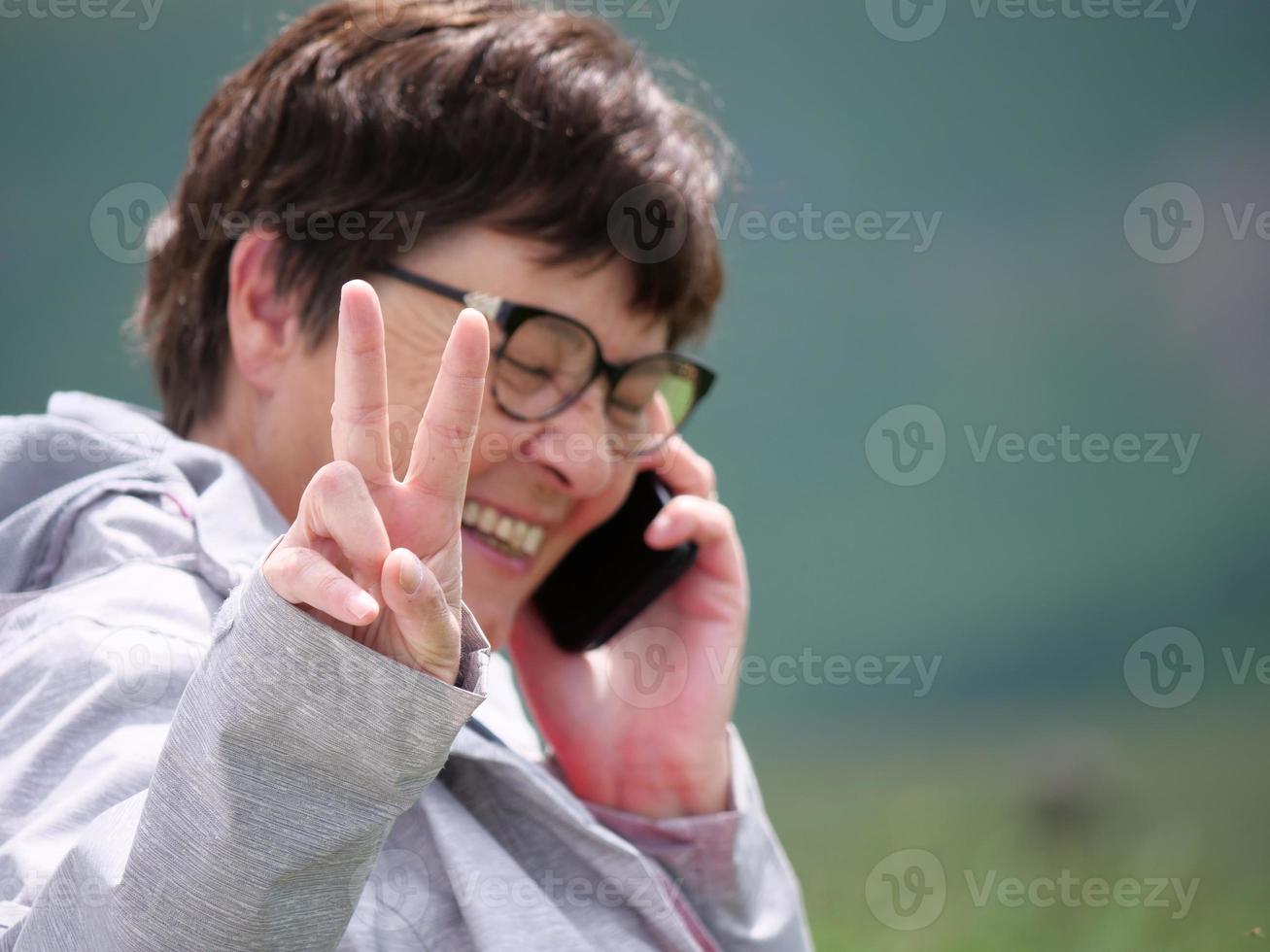 senior vrouw Aan de telefoon gelukkig na succes nieuws foto