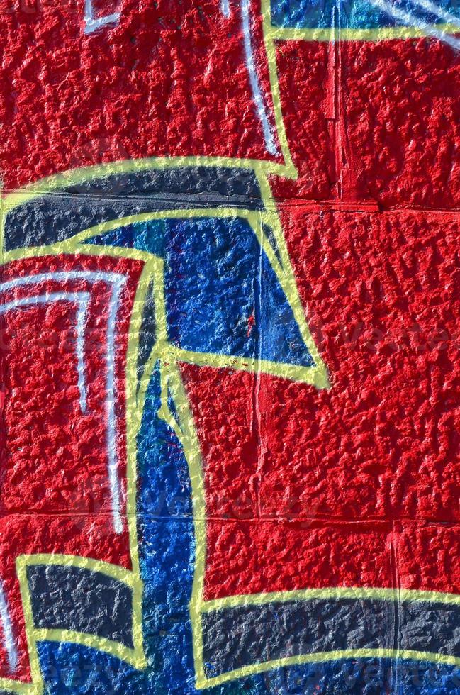 fragment van graffiti tekeningen. de oud muur versierd met verf vlekken in de stijl van straat kunst cultuur. gekleurde achtergrond structuur in warm tonen foto