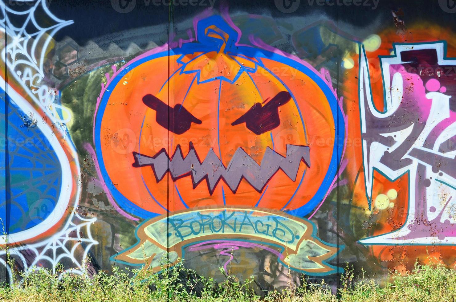 de oud muur, geschilderd in kleur graffiti tekening met aërosol verven. afbeelding van een onheil en eng oranje pompoen, bereid voor halloween foto