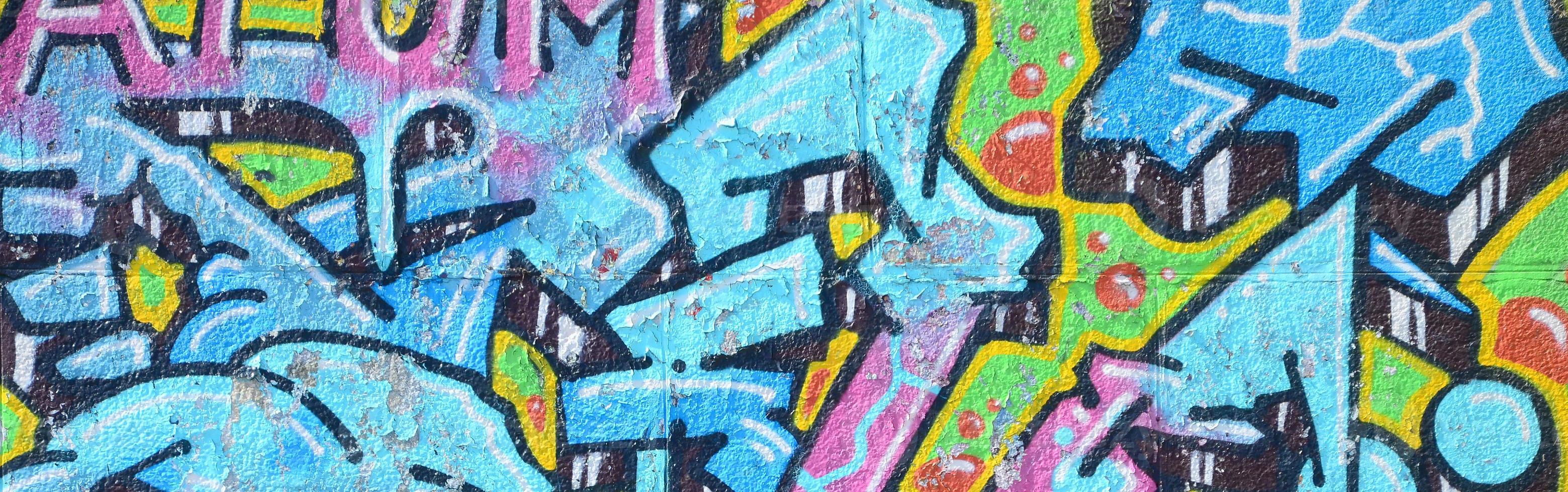 fragment van graffiti tekeningen. de oud muur versierd met verf vlekken in de stijl van straat kunst cultuur. gekleurde achtergrond structuur in verkoudheid tonen foto