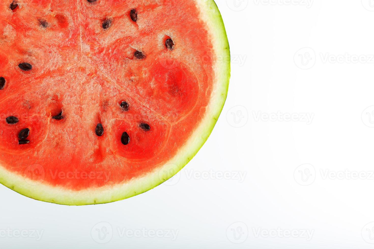 voor de helft plakjes van smakelijk en rijp rood watermeloen Aan een wit achtergrond, geïsoleerd structuur van sappig pulp van rijp rood watermeloen met zaden foto
