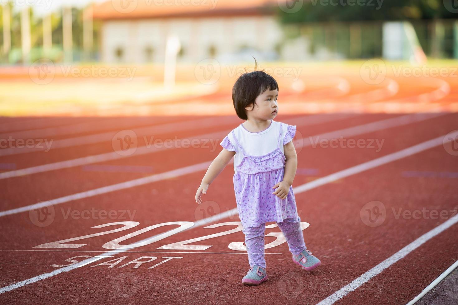 Aziatisch baby rennen begin in de nieuw jaar 2023. begin omhoog van loper meisje rennen Aan ras opleiding rijbaan ras bijhouden Gaan naar doel van succes. mensen rennen net zo een deel van aantal 2023. sport Gezondheid zorg. foto