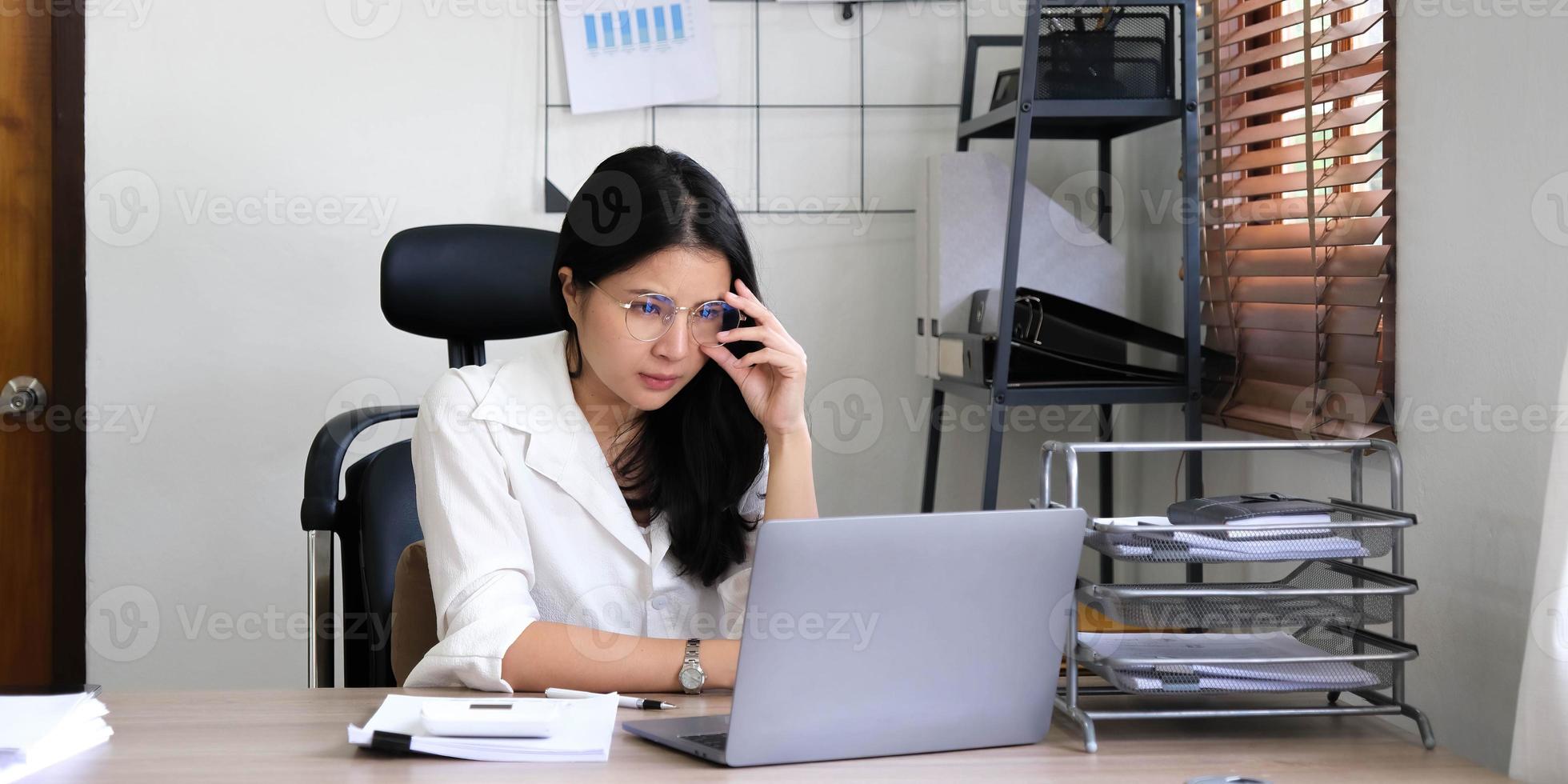 moe vrouw werknemer Holding hoofd Aan hand, op zoek Bij computer scherm, aan het doen moeilijk taak, hebben probleem met computer software. benadrukt uitgeput zakenvrouw lijden van hoofdpijn, gevoel verveeld. foto