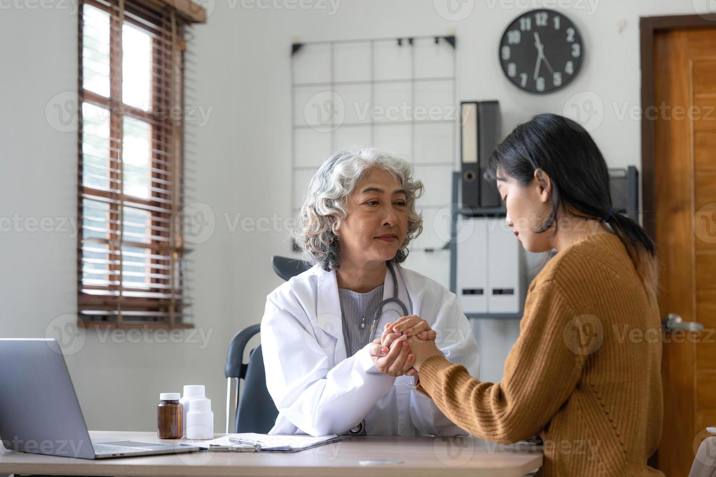 senior dokter assisteren een vrouw in haar kantoor. de geduldig is huilen en gevoel hopeloos foto