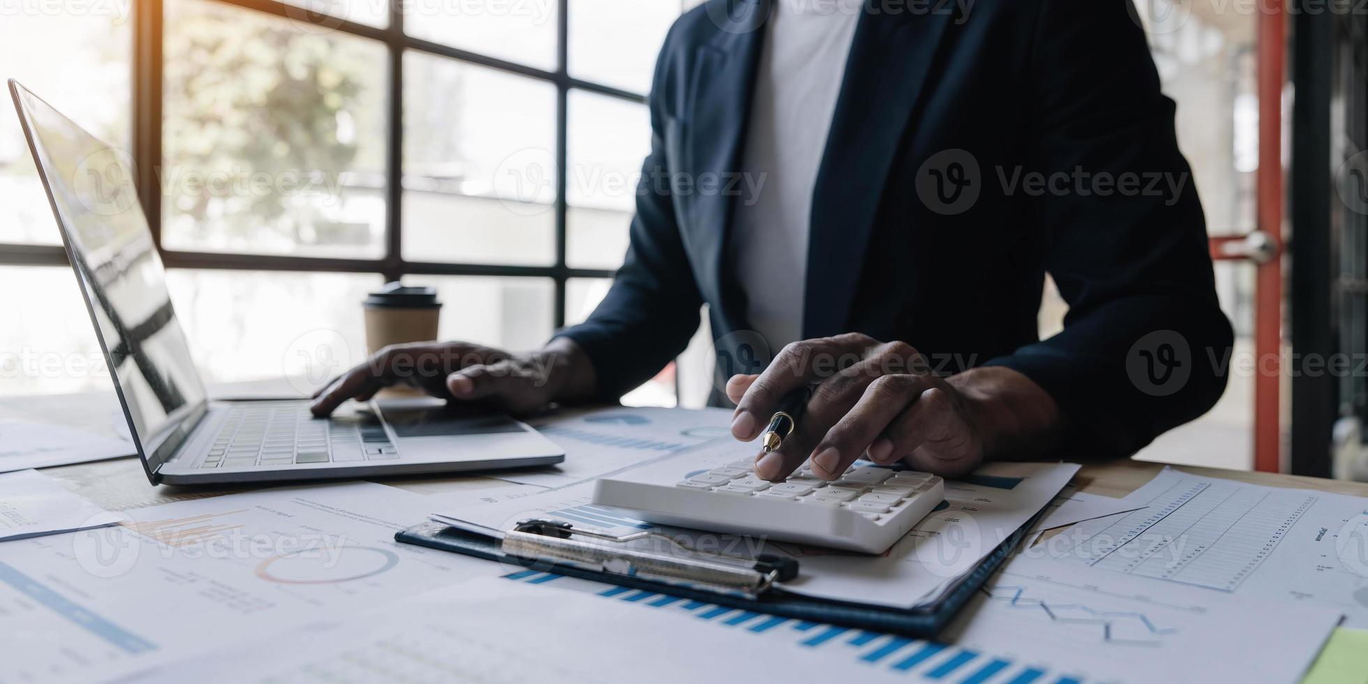 dichtbij omhoog Mens werken over financieel met rekenmachine Bij zijn kantoor naar berekenen uitgaven, accounting concept foto