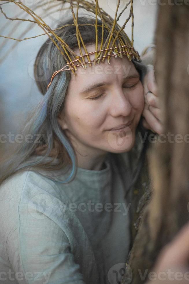 dichtbij omhoog keltisch gestileerd vrouw knuffelen boom met opgelucht glimlach portret afbeelding foto