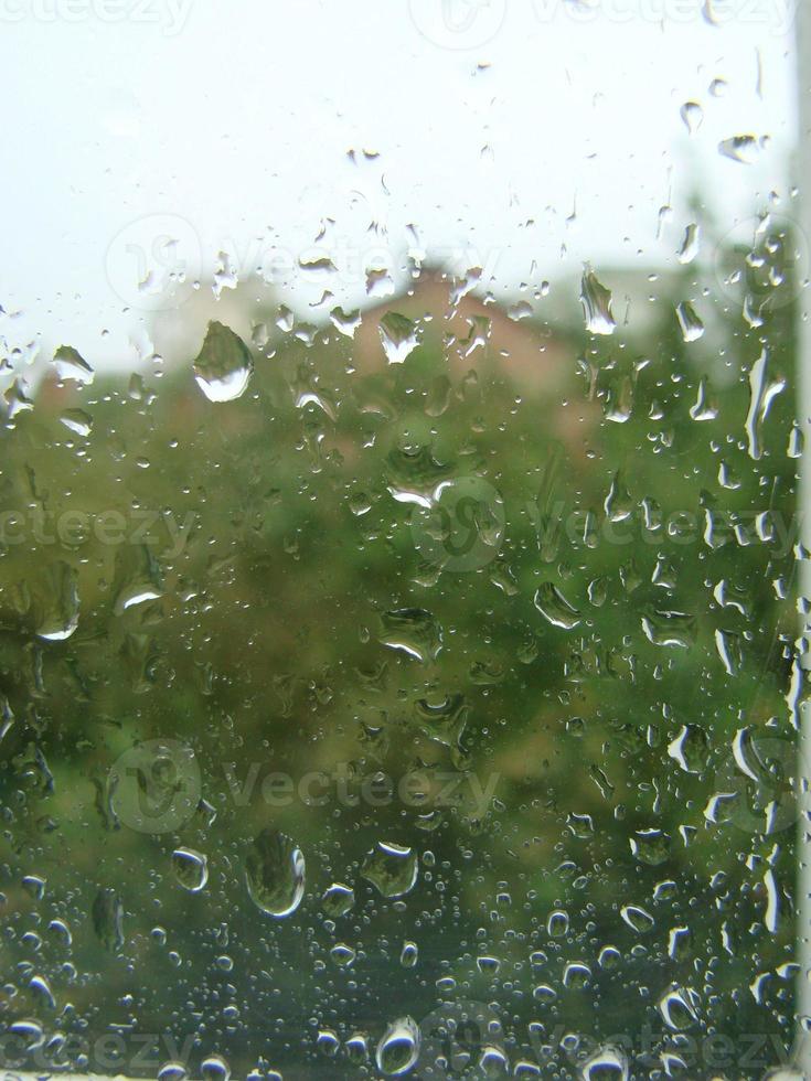 regenachtig dagen regen druppels Aan de venster oppervlakte foto