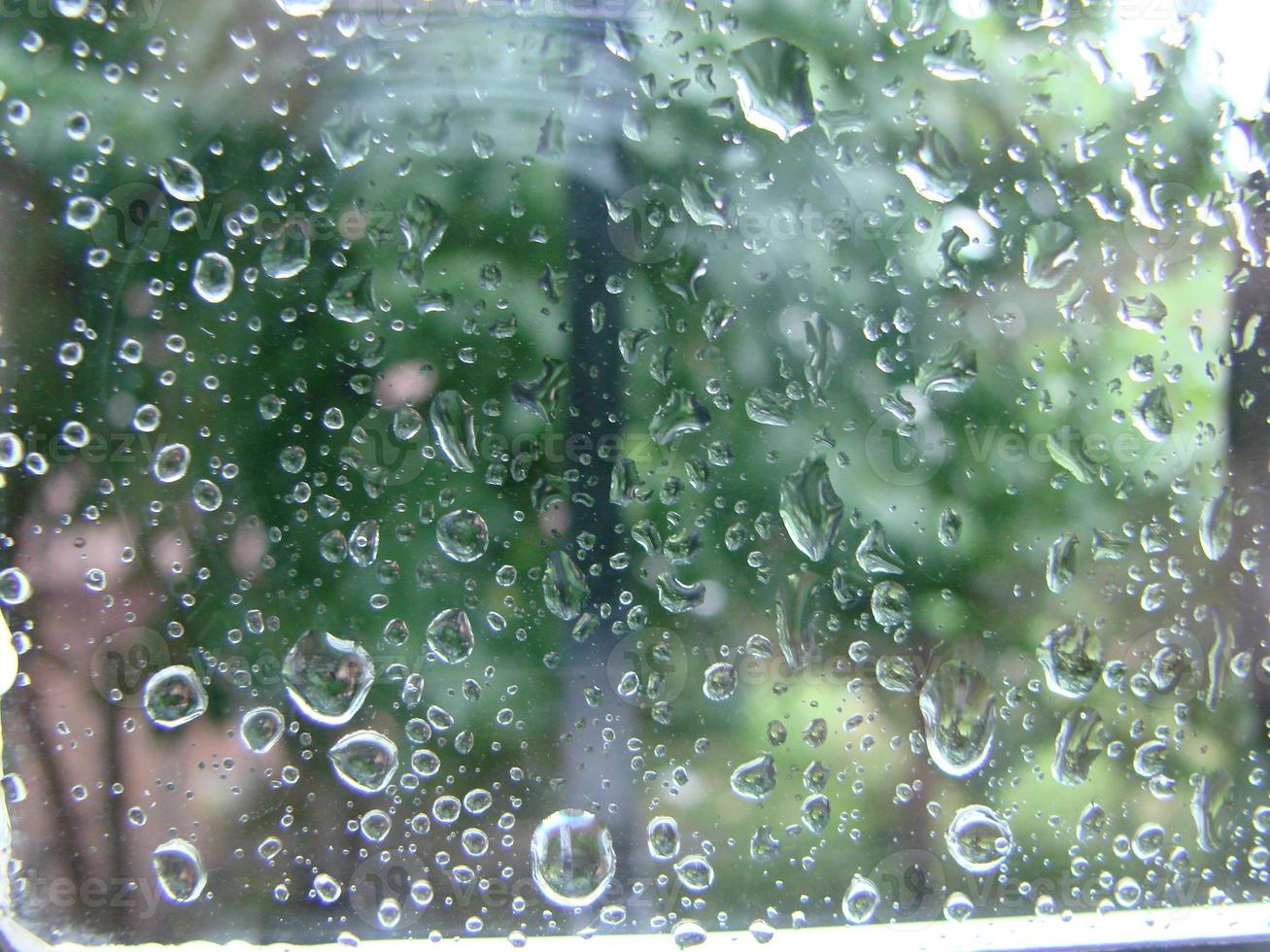 regenachtig dagen regen druppels Aan de venster oppervlakte foto