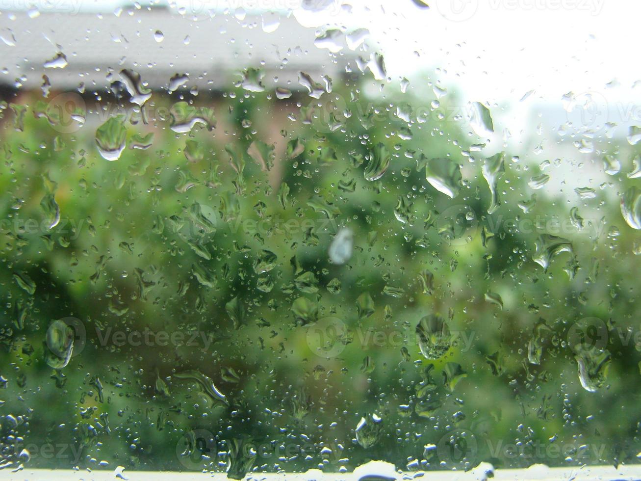 regenachtig dagen regen druppels Aan de venster oppervlakte foto