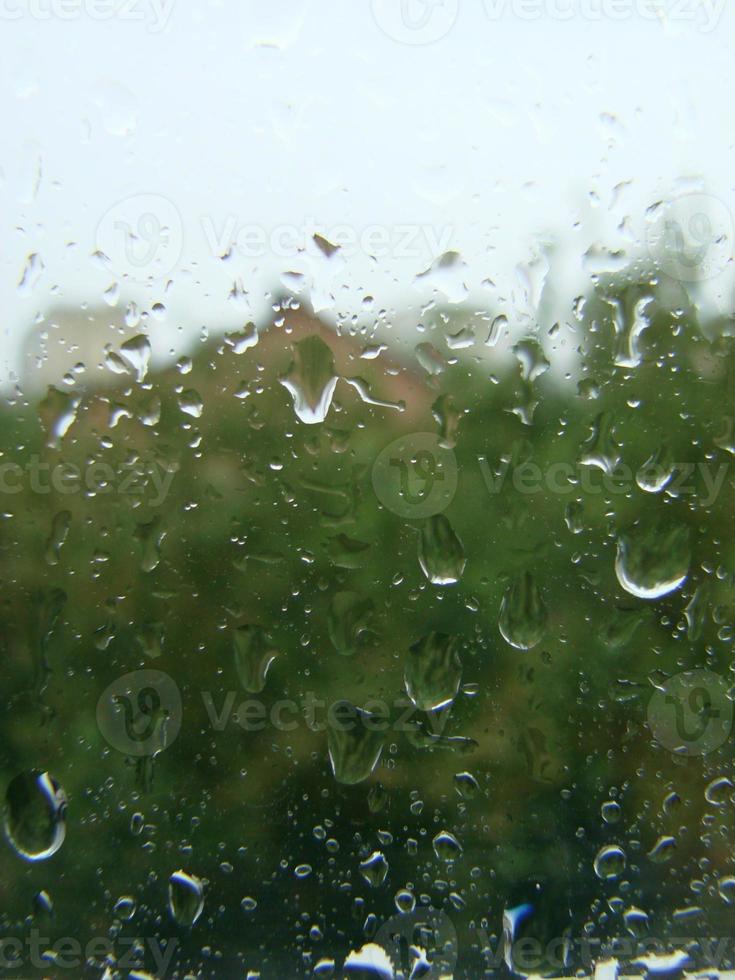 regenachtig dagen regen druppels Aan de venster oppervlakte foto