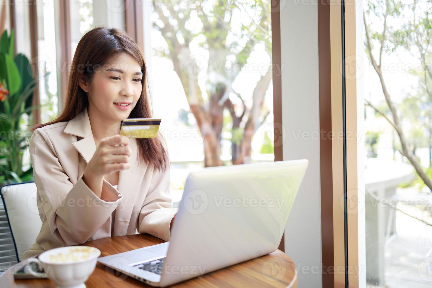 aantrekkelijk Aziatisch zakenvrouw gebruik makend van credit kaart voor goederen betalingen boodschappen doen online foto