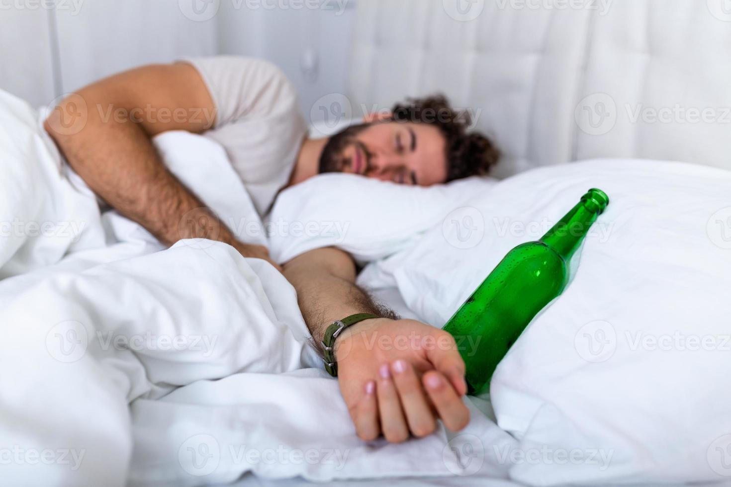 na feest drinken. dronken gebaard volwassen Mens aan het liegen Aan de bed en slapen na drinken veel van alcohol, leeg fles Aan de bed, alcoholisme, alcohol verslaving en mensen concept foto