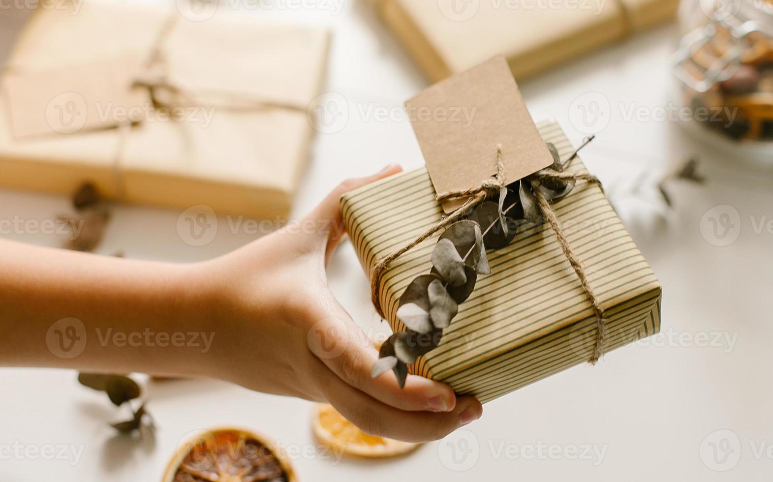 diy versierd geschenk in stijl van eco vriendelijk. doos verpakt in papier met etiket voor tekst en eucalyptus foto