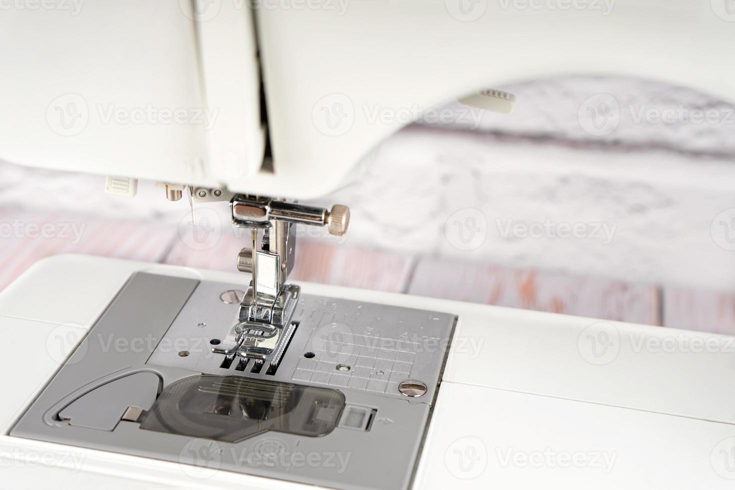 werken een deel van modern naaien machine, perser voet en naald- dichtbij omhoog foto