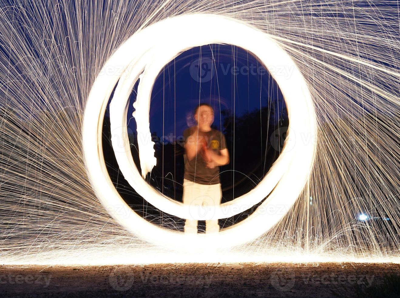 spinnen en brandend staal wol fonkeling brand in de cirkel vorm met lang snelheid Luik schieten gloeiend licht lijn naar de grond. foto