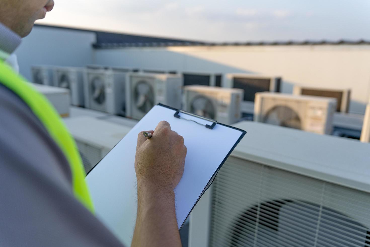mannetje industrieel ingenieurs controle en inspecteren de aanpassen de installatie nieuw compressor lucht conditioner volgens naar de van het bedrijf energiebesparend. inspecteur werken in fabriek. foto
