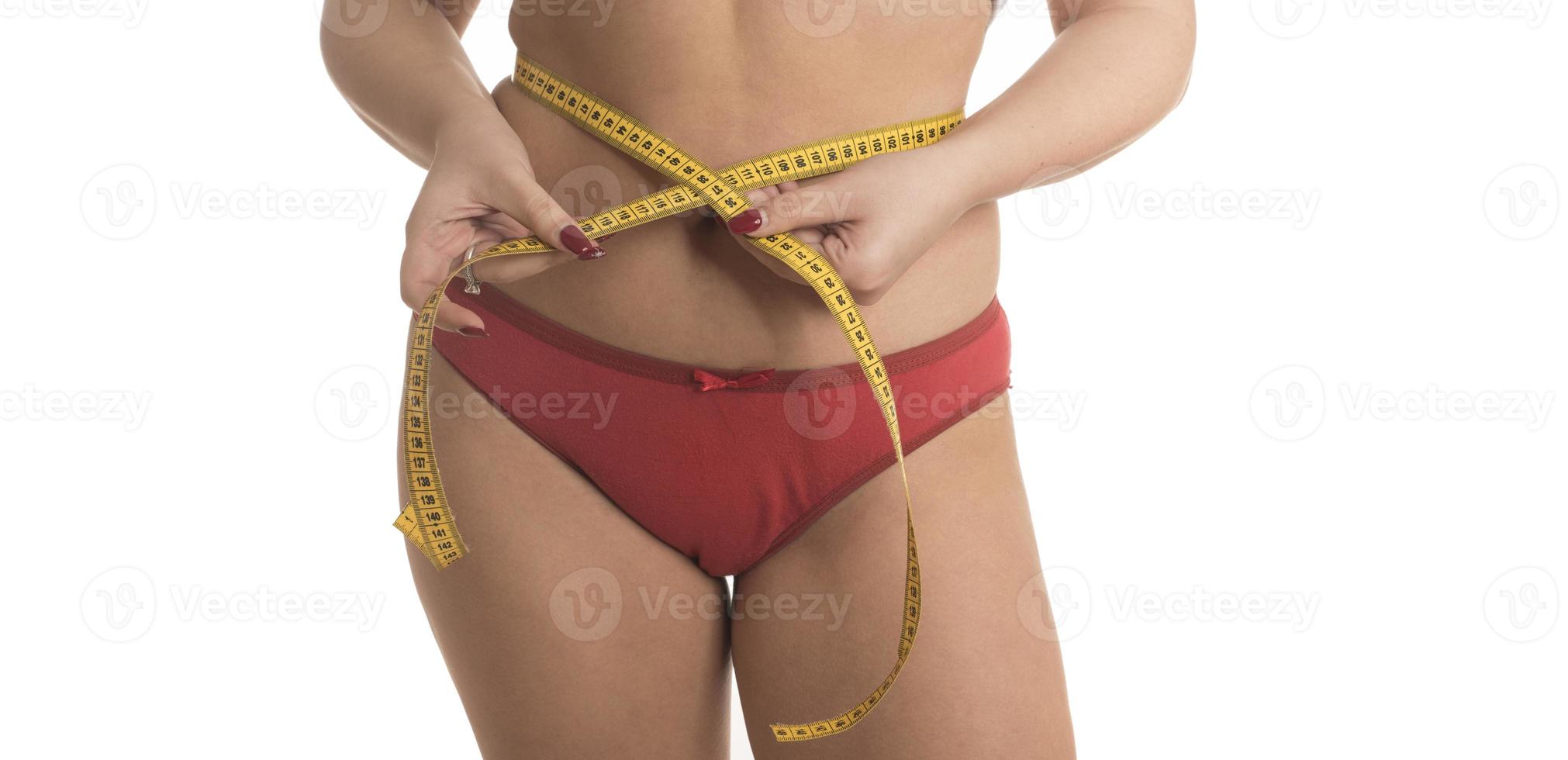 dik vrouw meten haar maag overgewicht, zwaarlijvigheid. geïsoleerd Aan wit achtergrond. foto