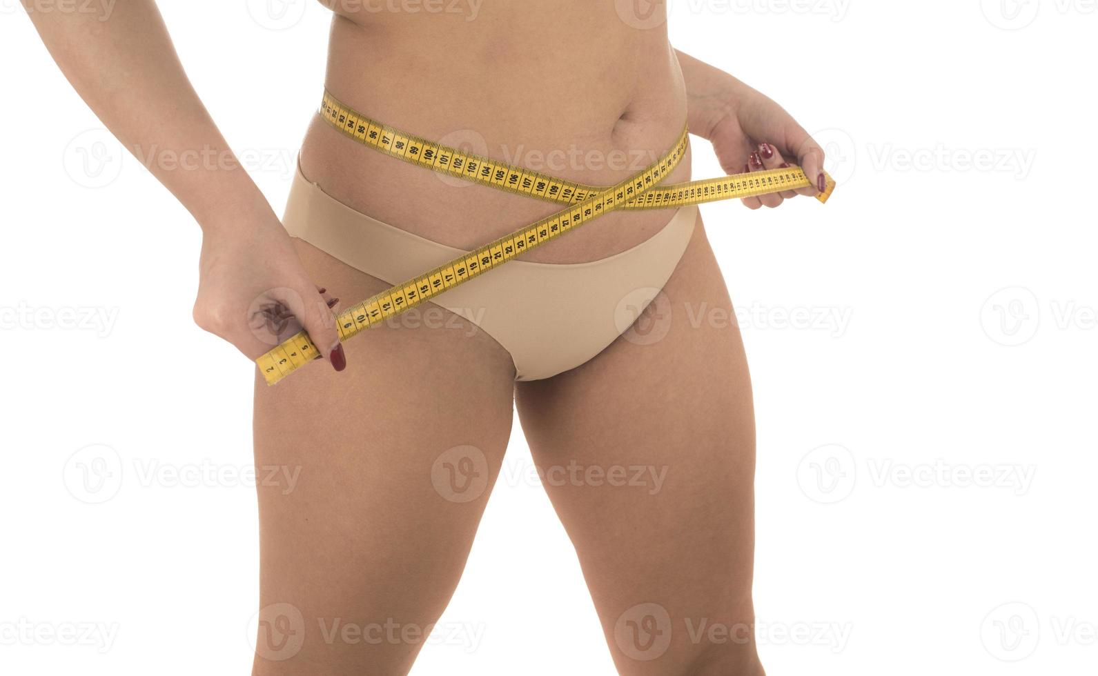 dik vrouw meten haar maag overgewicht, zwaarlijvigheid. geïsoleerd Aan wit achtergrond. foto