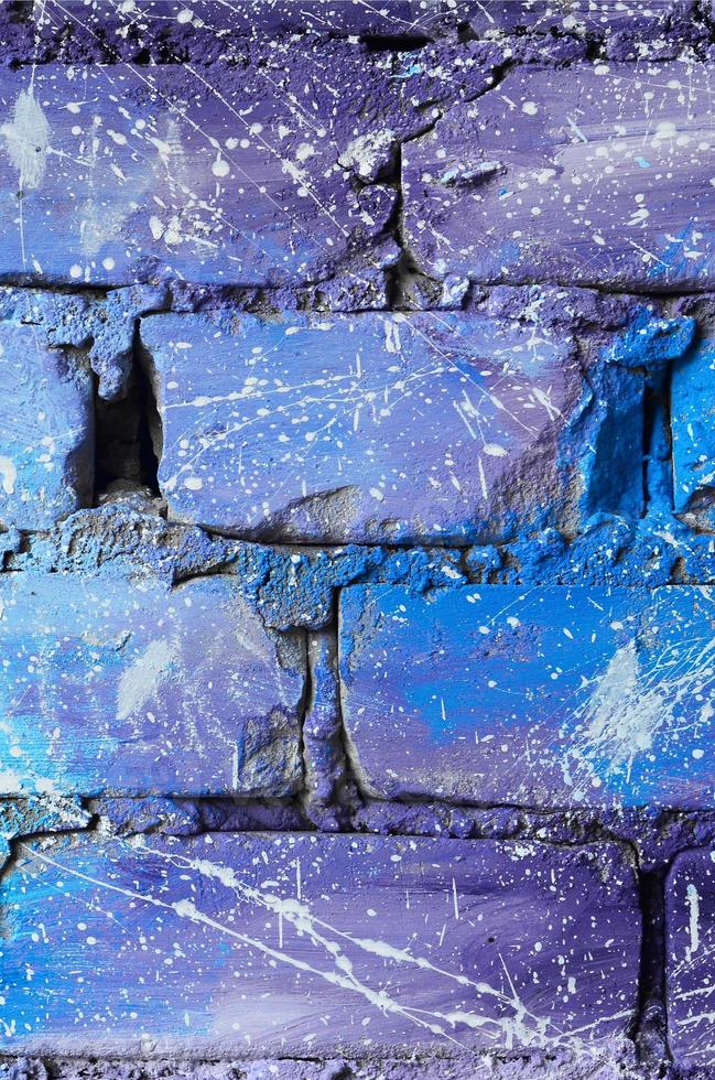 de structuur van de oud steen muur, geschilderd in blauw en Purper kleuren met onzorgvuldig uit elkaar geplaatst wit druppels en spatten dat visualiseren de sterren in buitenste ruimte foto