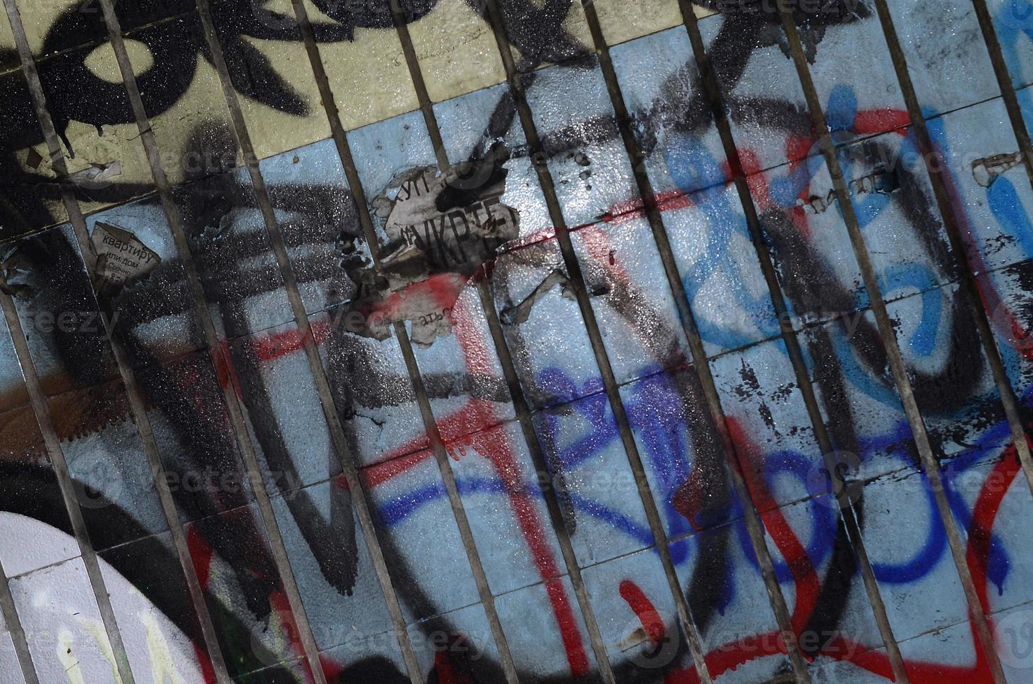 een fragment van graffiti tekening en een reeks van tags toegepast naar de muur van de oud tegel in de metro tunnel. de concept van straat kunst en vandalisme foto