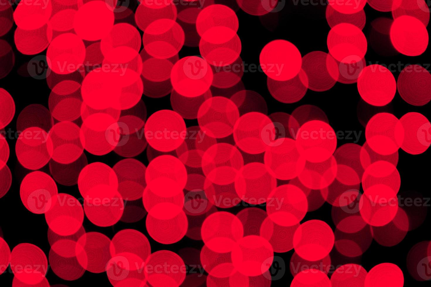 ongericht abstract rood bokeh Aan zwart achtergrond. onscherp en wazig veel ronde licht foto