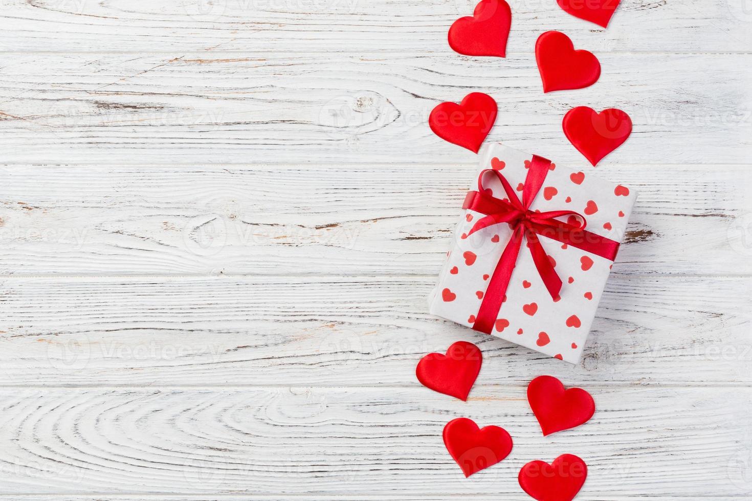 Valentijn of andere vakantie handgemaakt Cadeau in papier met rood harten en cadeaus doos in vakantie wikkel. Cadeau doos van geschenk Aan wit houten tafel top visie met kopiëren ruimte, leeg ruimte voor ontwerp foto