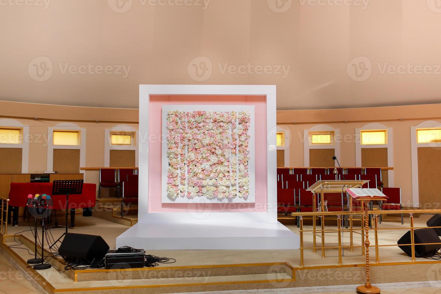 plaats voor de bruiloft ceremonie. plein boog voor bruiloft ceremonie een is versierd met roze en wit rozen en pioenen bloemen. bruiloft decor binnen banket Oppervlakte. foto