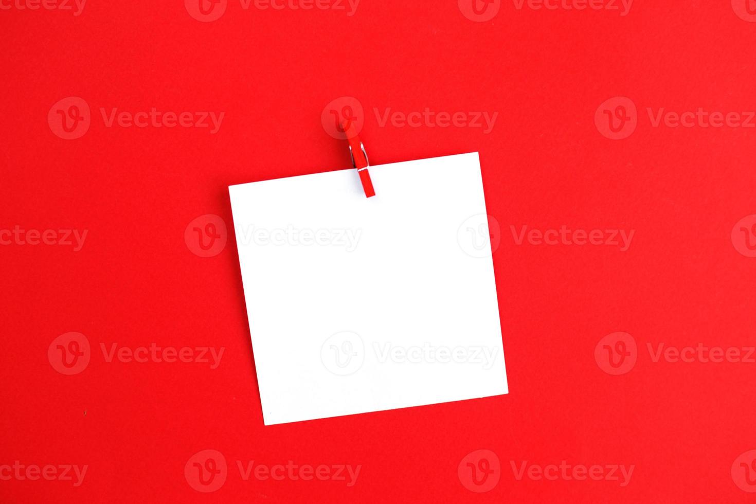 sticker met leeg mockup voor uw tekst hangende Aan de pin Aan rood achtergrond. kopiëren ruimte voor tekst foto