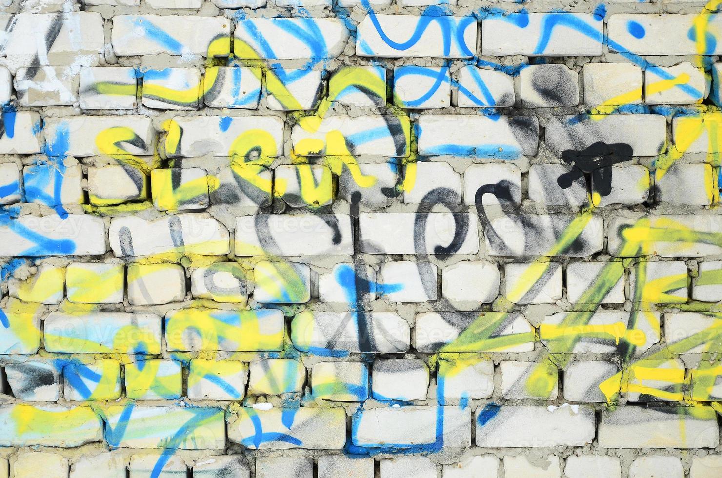 detailopname fragment van een graffiti tekening toegepast naar de muur door aërosol verf. de muur is verwend door een menigte van kleurrijk handtekeningen en tags van straat artiesten en hooligans foto