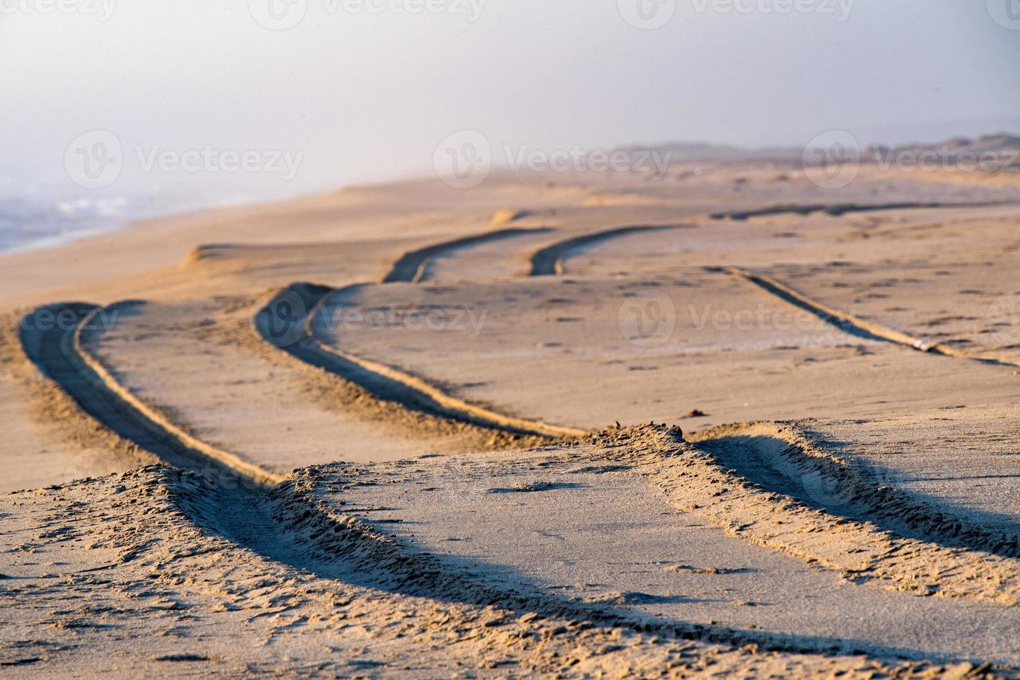 van de weg af auto band bijhouden detail Aan zand strand foto