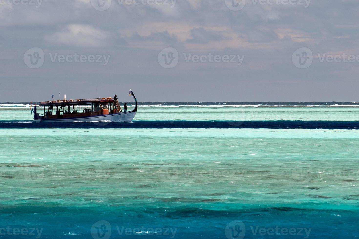 Maldivisch dhoni boot in blauw oceaan foto