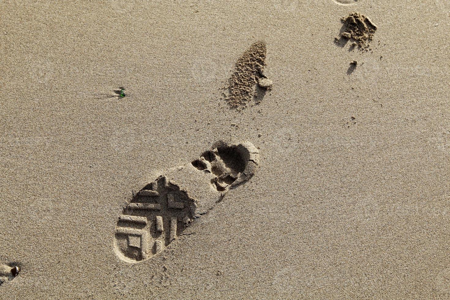 voetafdrukken in het zand bij de zee foto