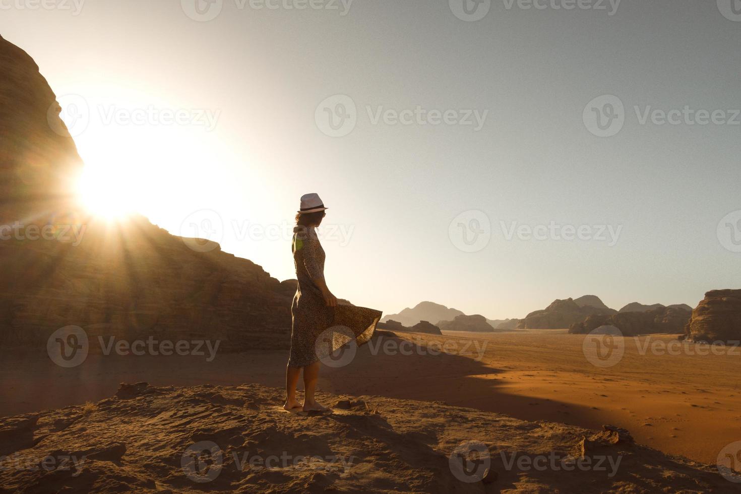 jong vrouw staan genieten van vredig moment van mooi kleurrijk zonsopkomst in woestijn bries met zonnevlam over- klif horizon.vintage stemming, concepten van reis, vrijheid, geluk, vreugde foto