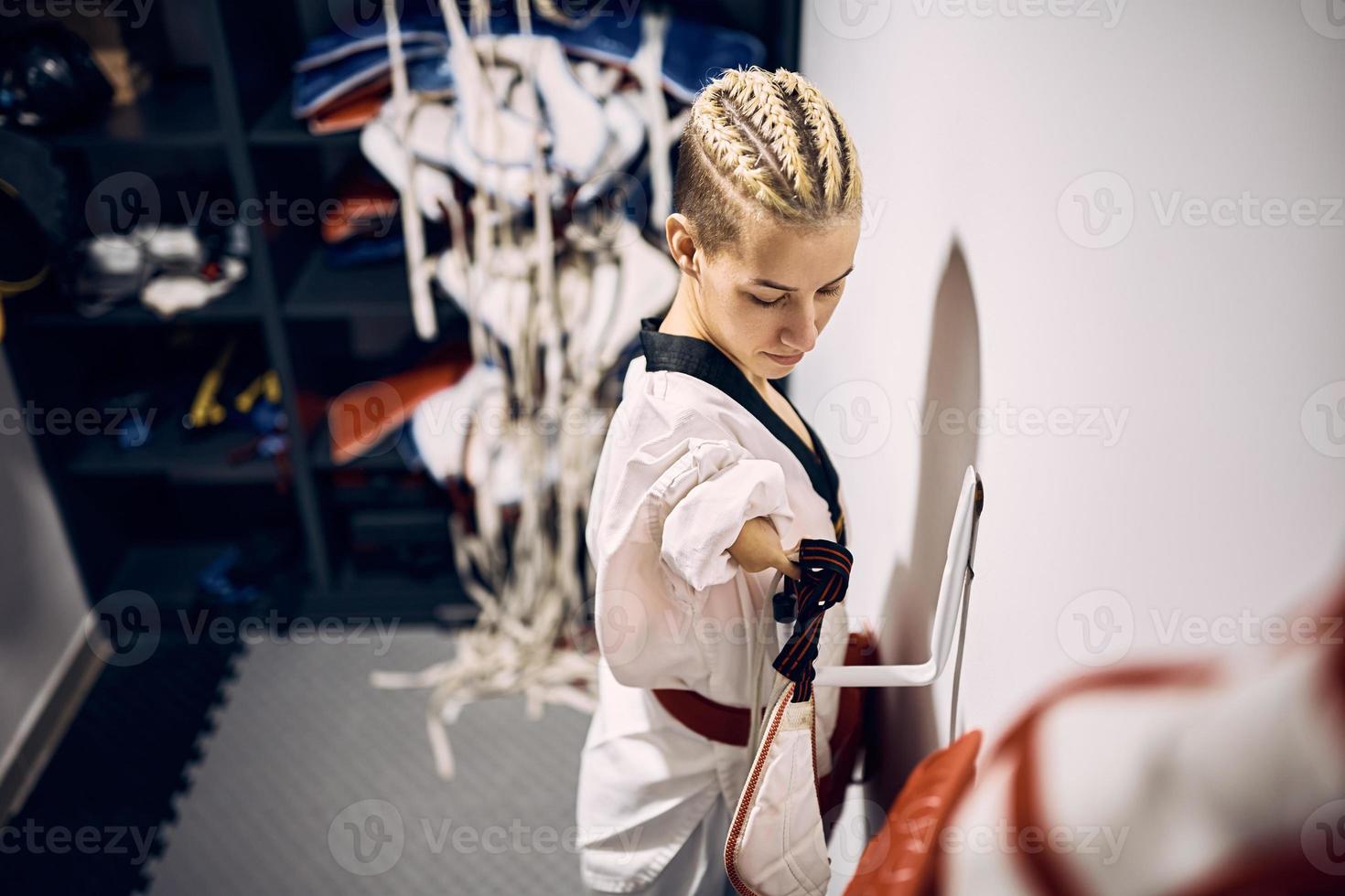 taekwondo vechter met para-vermogen krijgen klaar voor sport- opleiding in dressing kamer. foto