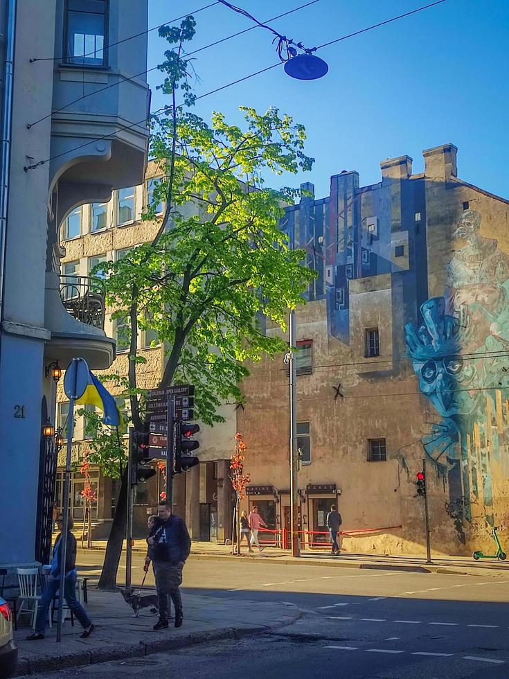 vilnius, Litouwen, 2022 - gebouw hoek met koel graffiti Aan kauno straat in Vilnius met groen bomen en wandelen mensen Aan zonnig voorjaar dag foto