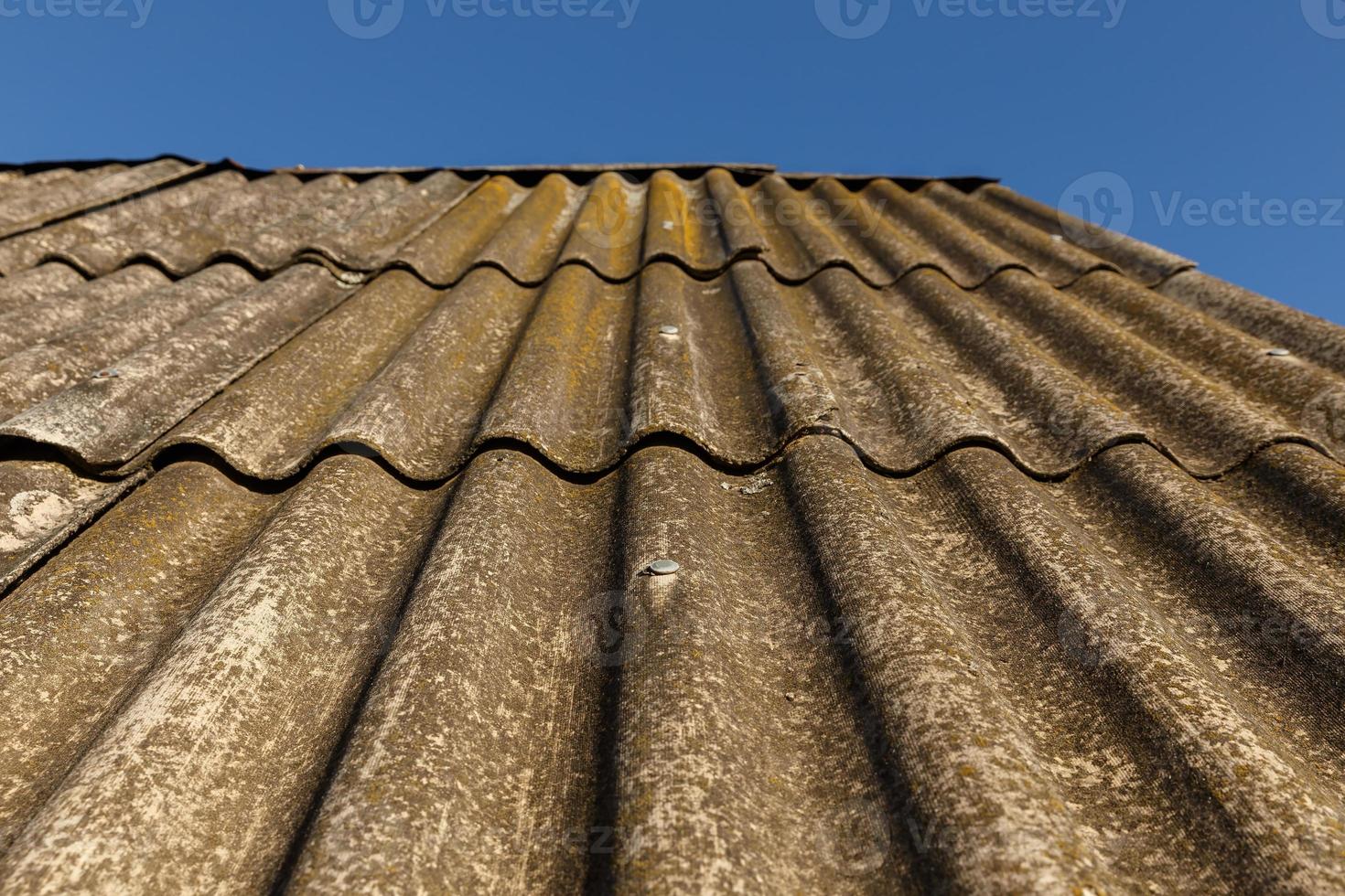 structuur van golvend oud dakbedekking leisteen. vol kader achtergrond. blauw lucht foto