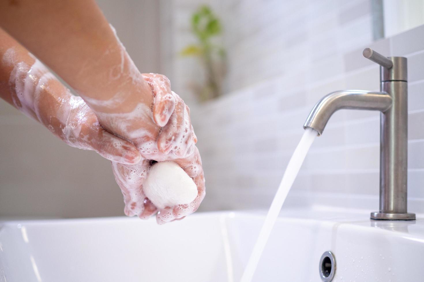 Dames wassen hun handen met zeep Aan de badkamer zinkt. veel voorkomend het wassen kan helpen beschermen tegen covid-19 virussen. foto